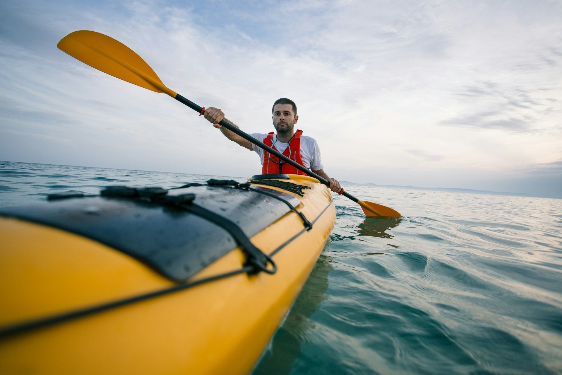 a man holding a paddle and ocean kayaking